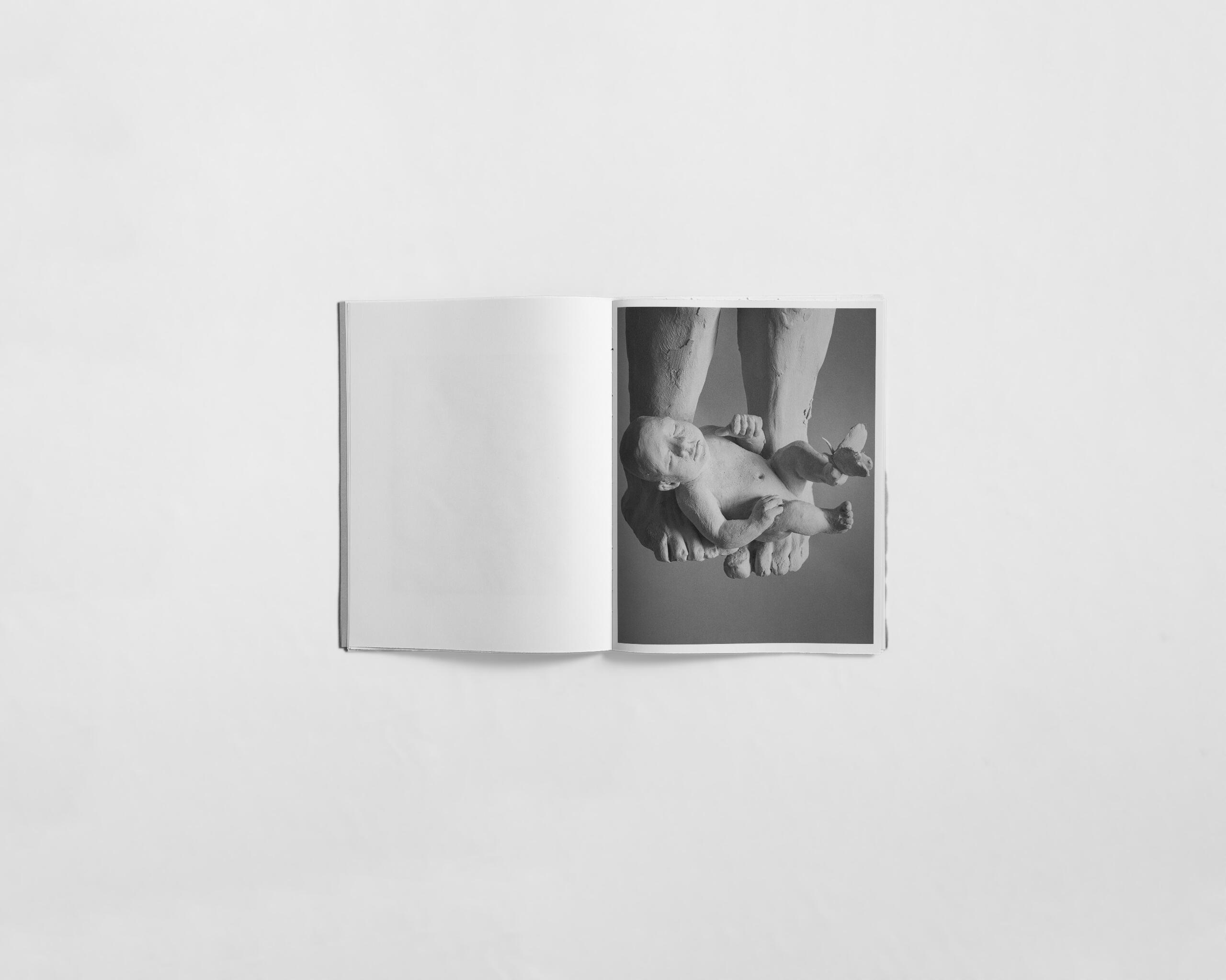 art book with sculpture of a baby by Gabrielle Carrère