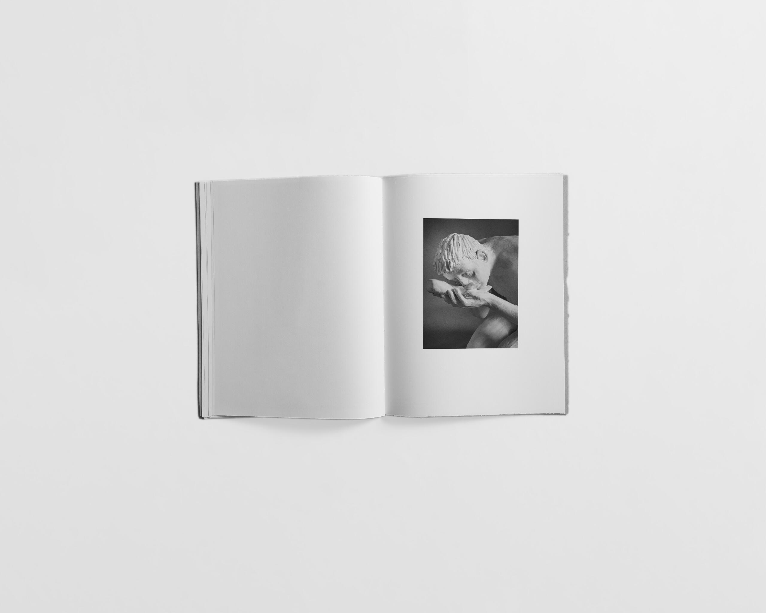 art book with sculpture of a man kneeling down by Gabrielle Carrère